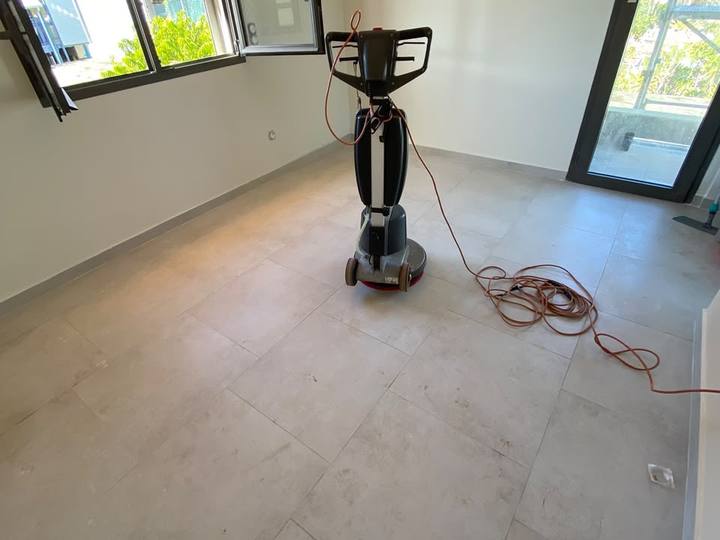 Monobrosse sur le carrelage d’une pièce vide après travaux, fenêtre ouverte