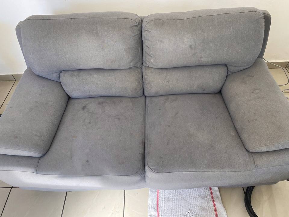 Canapé deux places gris taché sur l’assise et le dossier avant nettoyage, à Saint-Louis