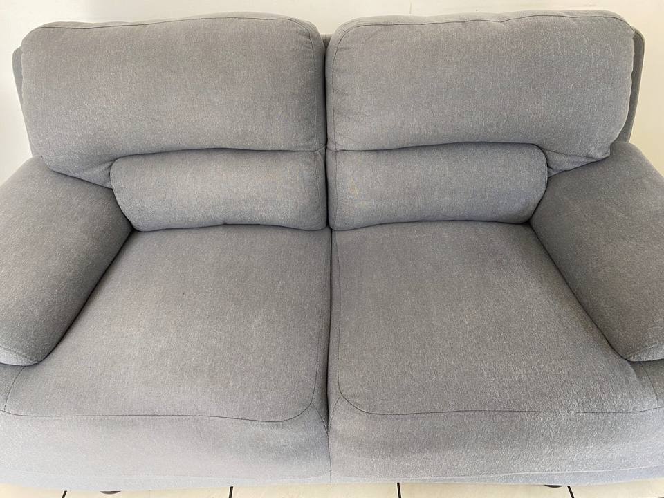 Le même canapé gris après nettoyage en profondeur, assise uniforme