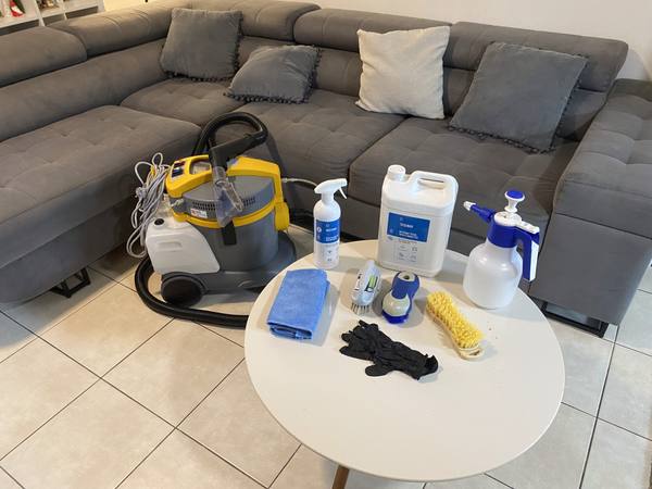 Machine de nettoyage, brosses et produits préparés sur une table avant un nettoyage de canapé à Saint-Louis